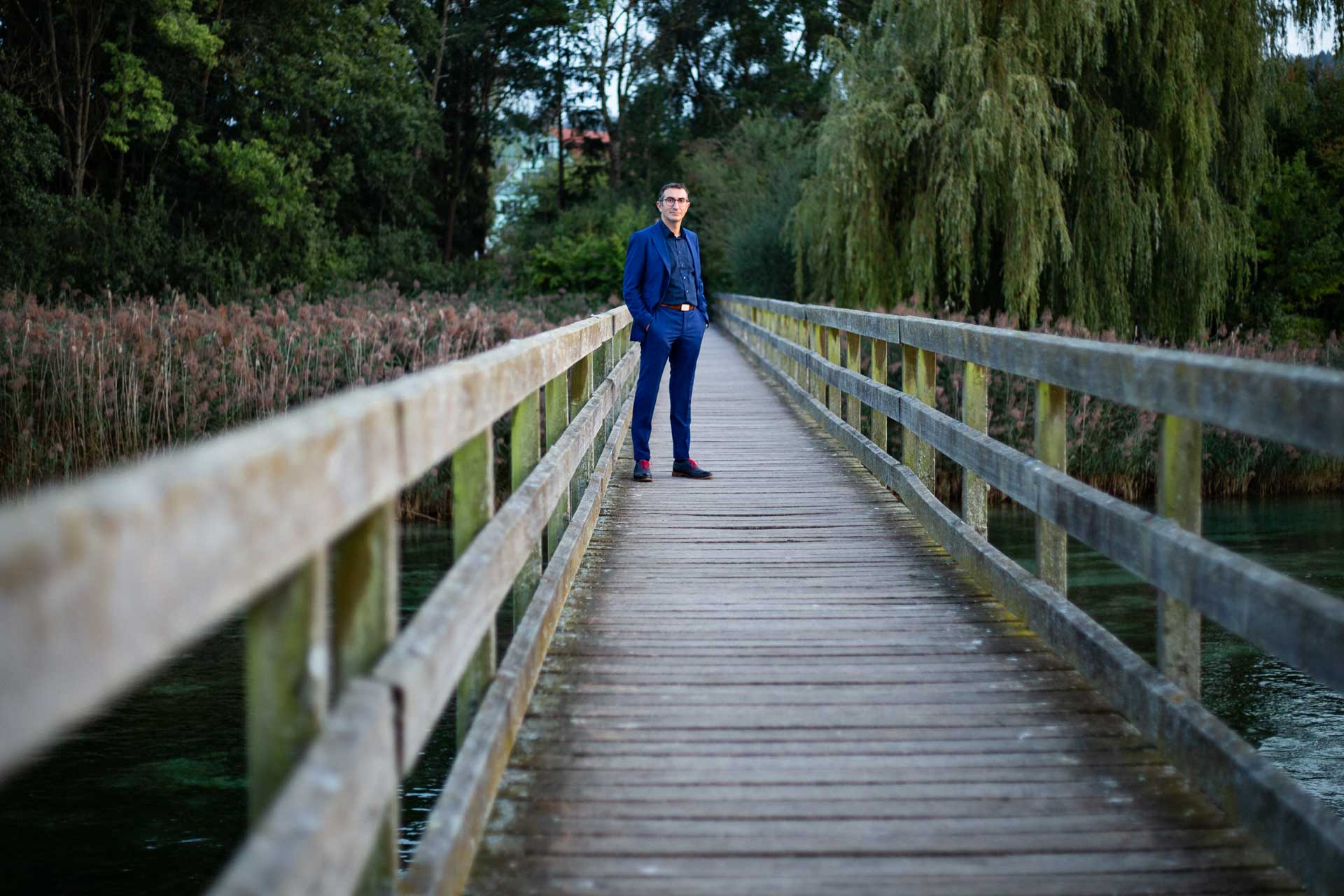 Tommaso Rubino auf Brücke mit Bäume und See